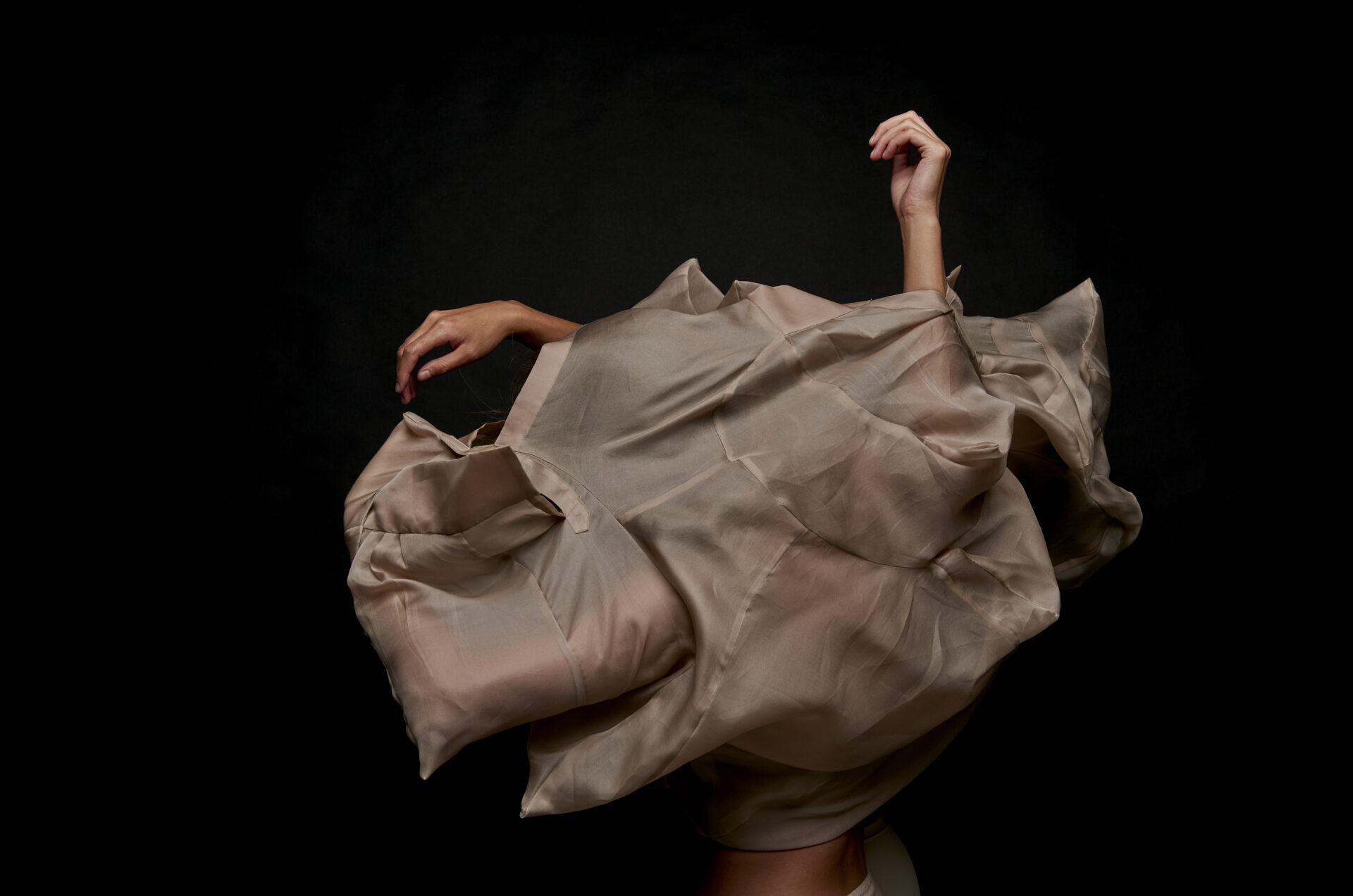 Dancer trapped in fabric. Arms protrude at the top.